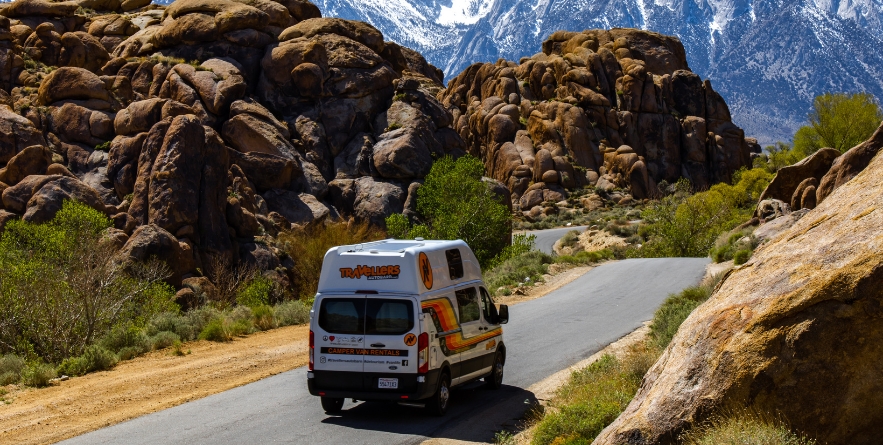 Campervan driving on road through Lone Pine