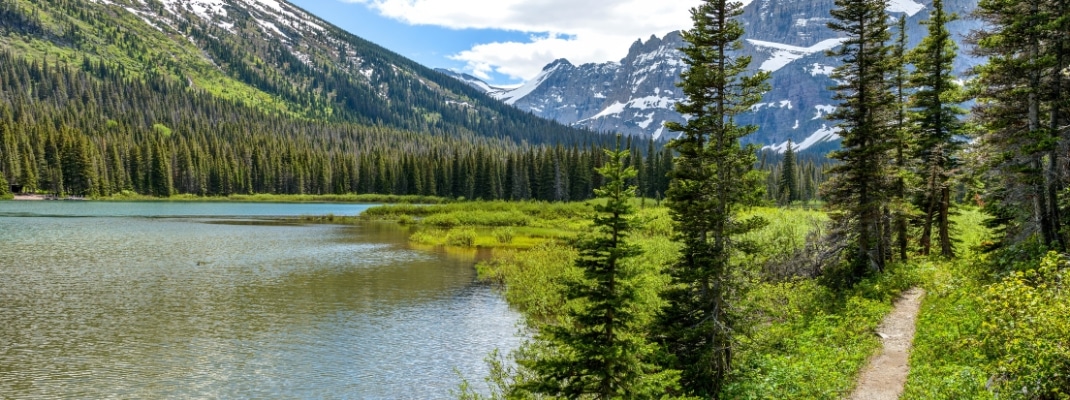 Mountain Lake Trail - A spring view of a hiking trail along Lake Josephine at the base of Mount Gould in Many Glacier region of Glacier National Park, Montana, USA.
