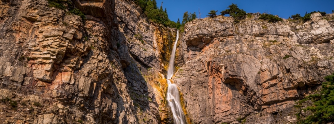 The Apikuni Falls is only a small trickle in the fall season in the Many Glaciers part off Glacier National Park in Montana, USA. Long exposure photo 
