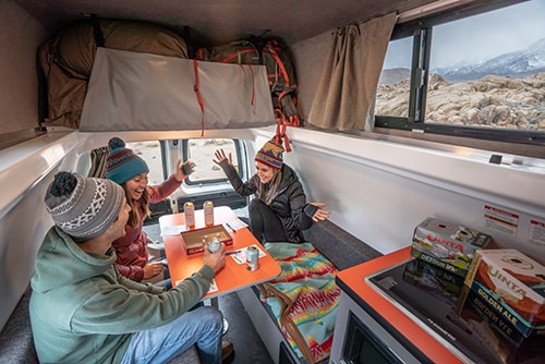 group of friends in a campervan with games