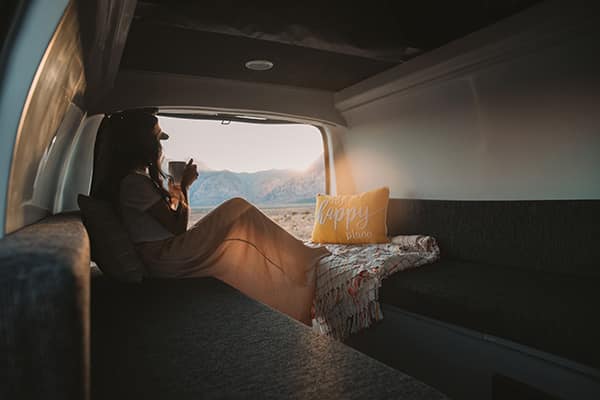 Female sitting in the back of a campervan