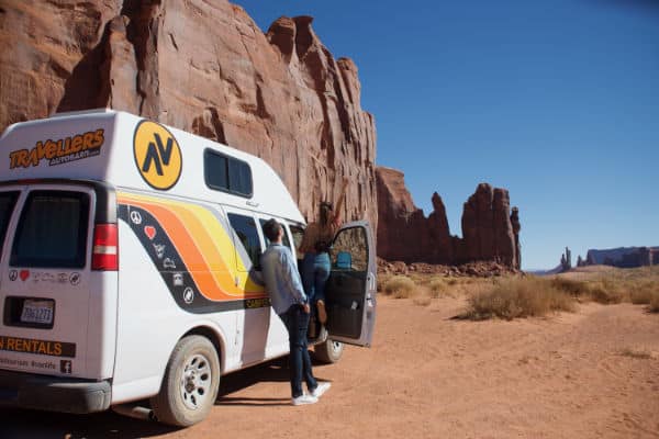 Man standing next to campervan enjoying view