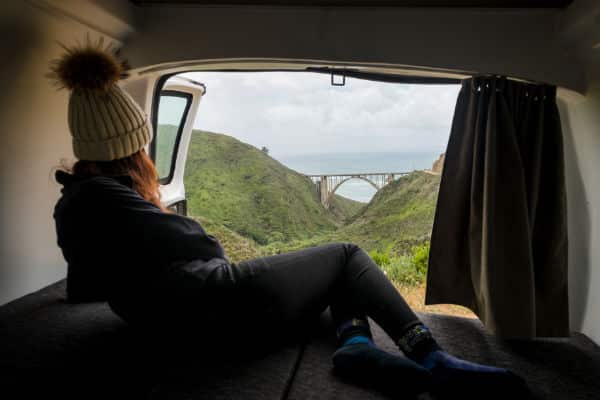 woman in campervan looking out at ocean