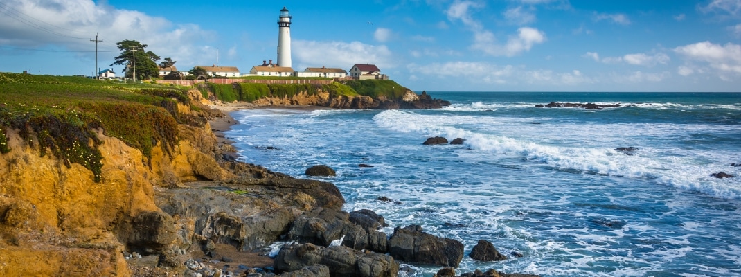 Rocky coast and view of Piegon Point Lighthouse in Pescadero, California.
