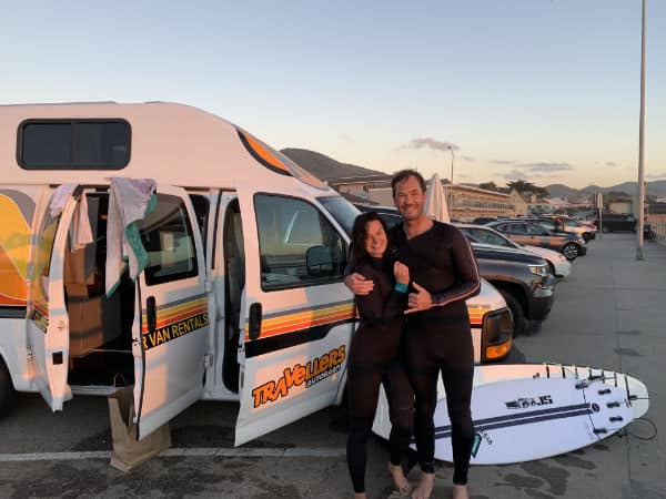 Male and female surfers by Travellers Autobarn campervan