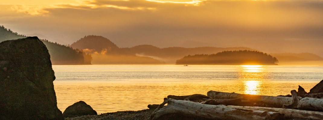 View of San Juan Islands during sunset sunrise with orange glow over water
