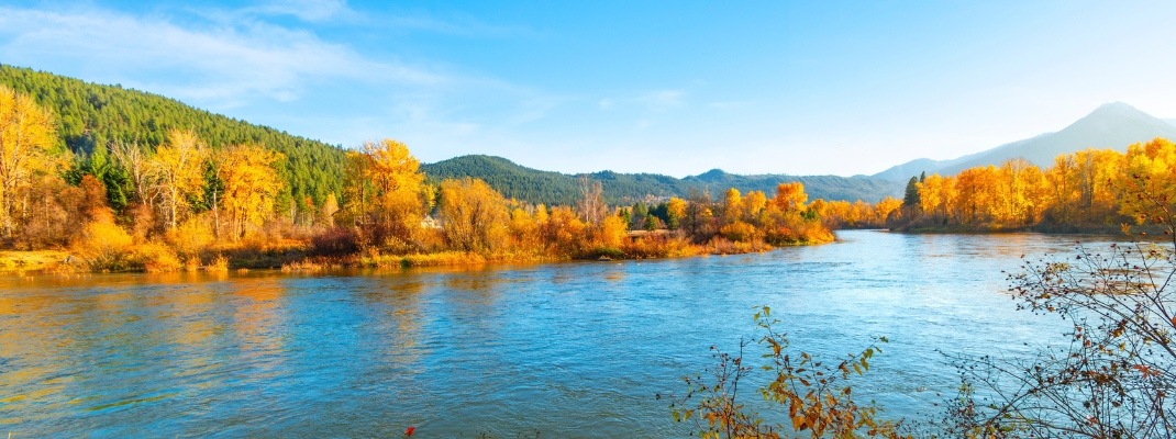 View of the Wenatchee River at autumn with fall colors on the leaves from Blackbird Island at Leavenworth, Washington, USA. 
