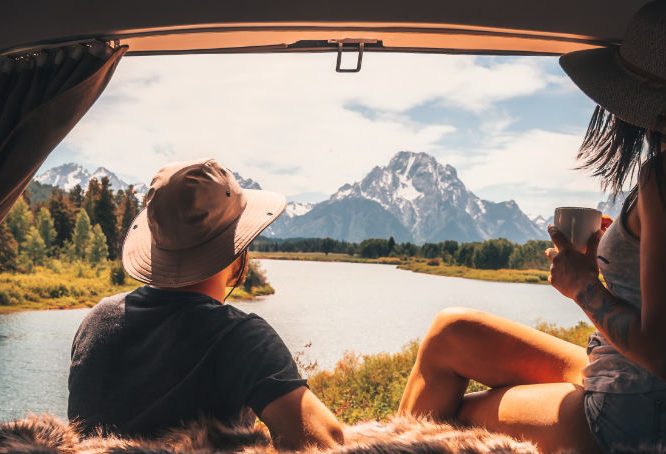 Couple looking at mountains from campervan bed
