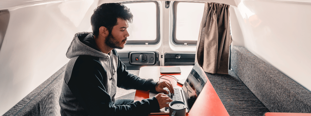 Person on laptop in campervan
