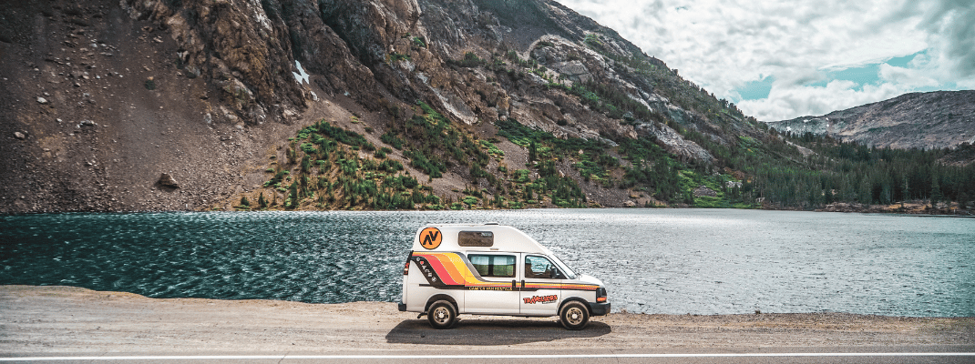 Campervan next to lake in mountains