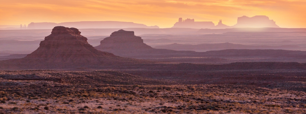 Valley of the Gods rock formation with Monument Valley at sunrise
