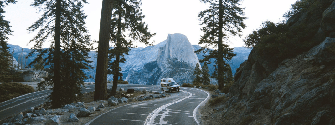 Campervan on road with backdrop of Yosemite National Park, USA