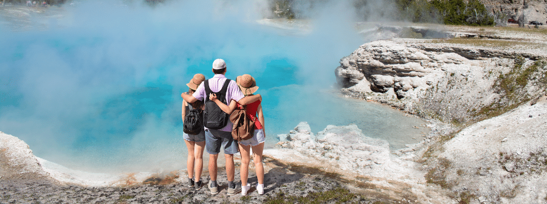 Family relaxing and enjoying beautiful view of gazer on vacation hiking trip, Yellowstone National Park