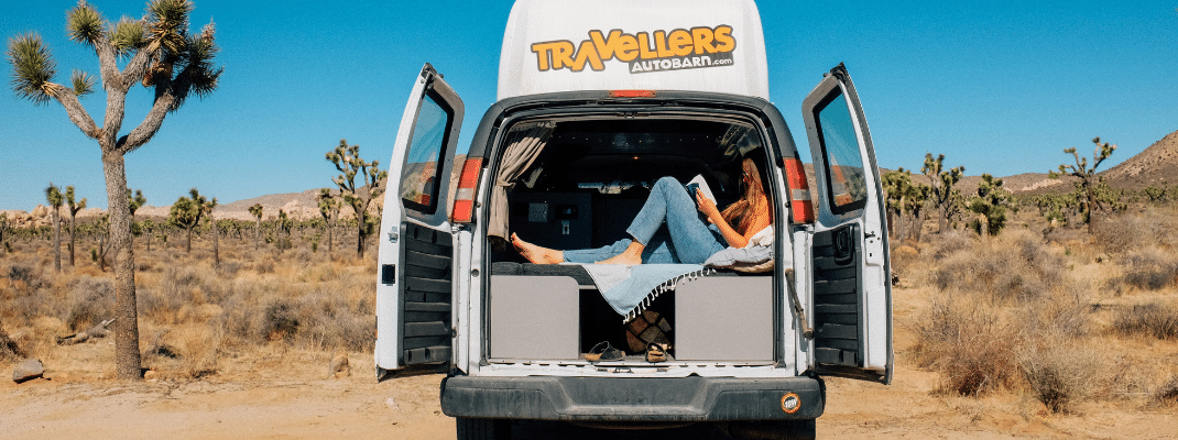 Person reading a book in back of campervan, Joshua Tree National Park, USA