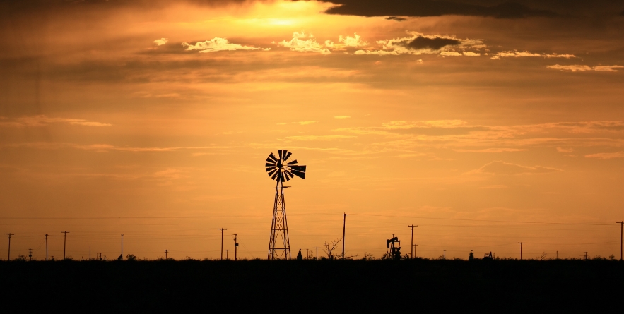 West Texas Sunset. Windmill and pump jack.