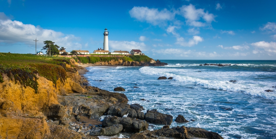 Rocky coast and view of Piegon Point Lighthouse in Pescadero, California.