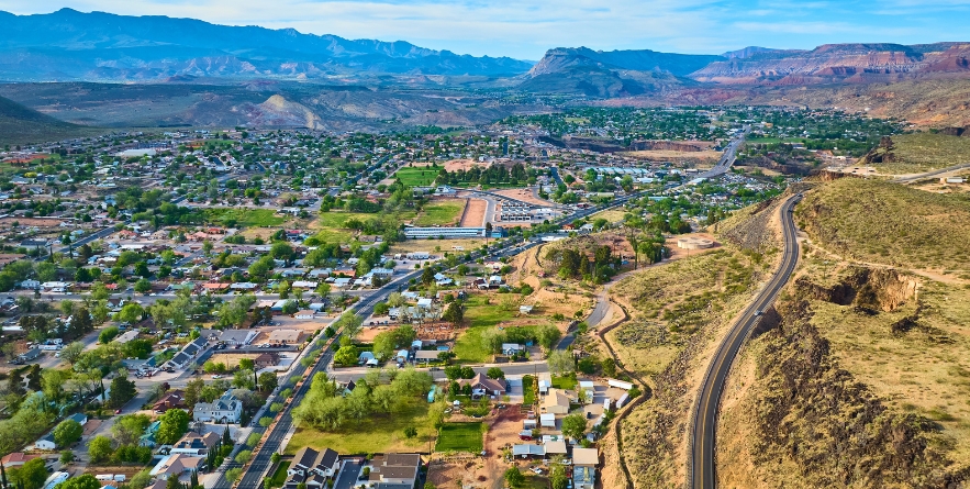 Aerial Suburban Neighborhoods and Desert Mountains in Hurricane Utah Fly Over