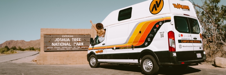 campervan next to joshua tree national park sign