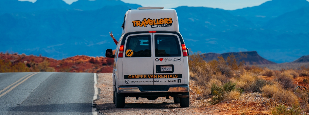 Campervan next to road with peace sign out window