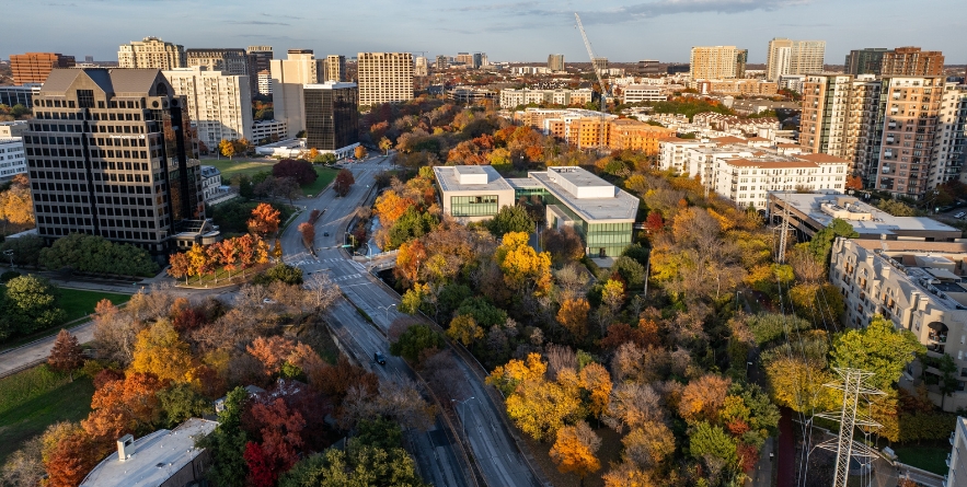 Aerial view of buildings and fall foliage in Uptown neighborhood near downtown Dallas cityscape landscape during autumn season