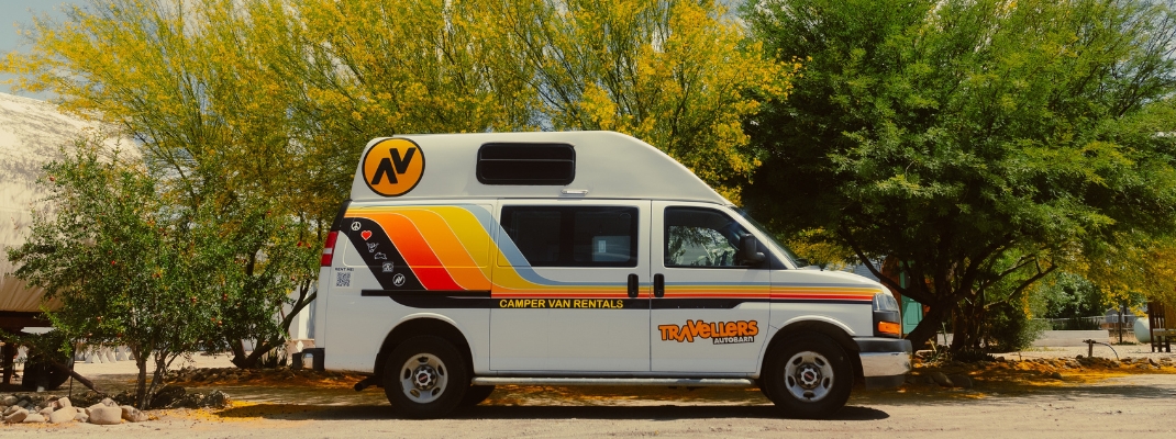 Campervan parked next to floral tree