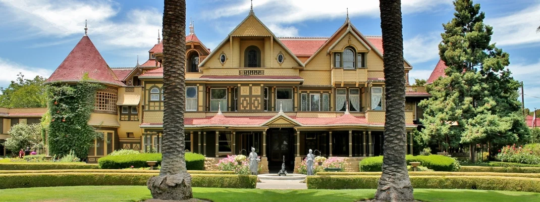 A front yard view of the Winchester Mystery House on a sunny day in San Jose California