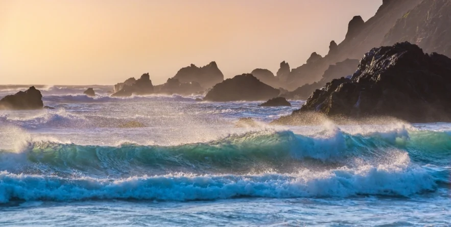 Breakers roll in at sunset on Pfeiffer Beach in Big Sur, California.