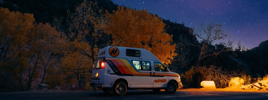 Campervan parked on side of road at night during fall, usa